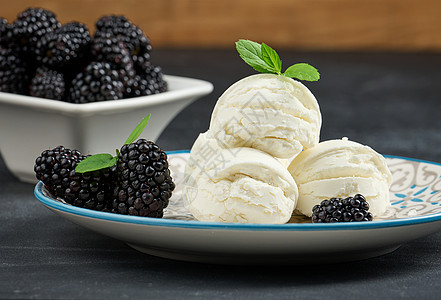 三勺白冰淇淋 在圆盘里 黑桌上有薄荷叶香草食物浆果白色牛奶甜点薄荷水果黑色奶油图片