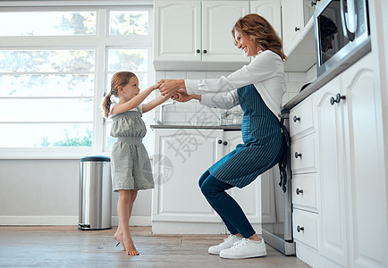 我也可以给你看一些很酷的舞步 一位祖母和她的孙女在家里的厨房里跳舞图片