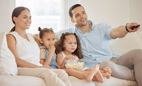 狂欢观看我们最喜欢的家庭节目 一个男人在家里和家人一起看东西时使用电视遥控器图片