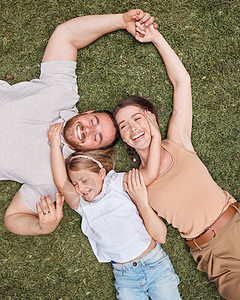 是一个幸福的家庭 一个年轻家庭躺在自家花园的草地上和亲近的高角度拍摄图片