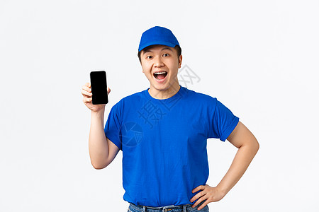 技术 在线购物和航运概念 穿着蓝信使制服的笑笑笑像人送货员 站着欢乐 展示移动电话屏幕 命令跟踪应用程序(PS)图片