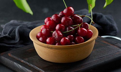 黑桌上的木板上的红樱桃叶子绿色水果食物盘子甜点营养工作室浆果团体图片