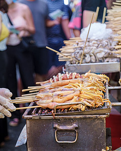 中国城市泰国曼谷Griilled鱿鱼 市场上的Calamari鱼类bbq传统烧烤建筑游客街道人群食物黑色海鲜炙烤图片