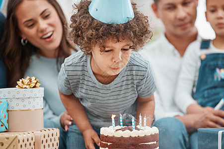 大男孩把蜡烛都吹光了 一个可爱的小男孩 在家和家人一起庆祝一个生日呢?图片