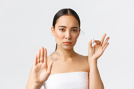 美容 个人和私密护理月经卫生概念 穿着毛巾的严肃美丽的亚洲女孩 展示停止手势和卫生棉条 鼓励使用月经杯或有机产品背景图片