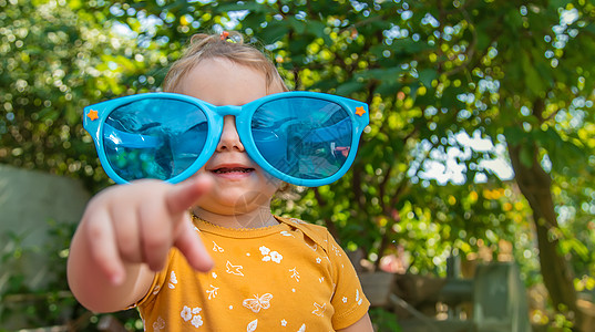 孩子们喜欢戴眼镜的自然 有选择地集中注意力草地场地享受公园幸福孩子女性喜悦风镜游戏图片
