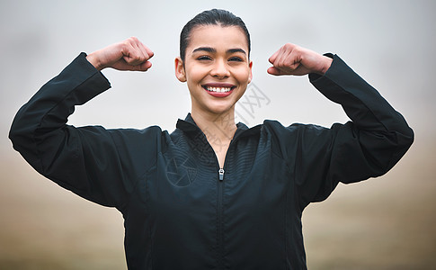 巧妙的柔软 一个有魅力的年轻女运动员的剪裁肖像 在站在外面时伸展她的二头肌图片