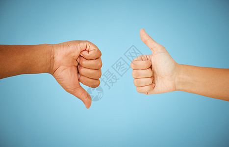 一个不明确的结果 无法辨认的人在蓝色背景下竖起大拇指和朝下竖起大拇指图片