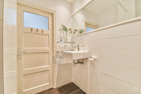 浴室门边的下沉和镜子家具卫生间住宅橱柜架子卫生龙头家庭内阁水平图片