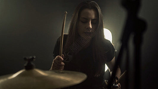 一位精力充沛的女性鼓手演奏鼓包音乐会乐器玩家手指成套女孩活力乐队女士娱乐图片