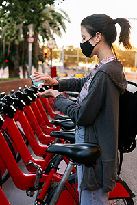 女孩在租自行车前用面具洗手图片