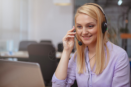 友好的客户支助操作员 在呼叫中心使用耳头耳机顾问讲话代理人接待员女性销售量学生职业服务台工作图片