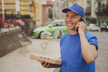 英俊的年轻送货员 带披萨盒邮递员工作享受纸盒服务客户消费者餐厅顾客娱乐图片