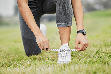 一个无法辨认的年轻女运动员在外出锻炼时绑着她的鞋带 保持紧绷图片