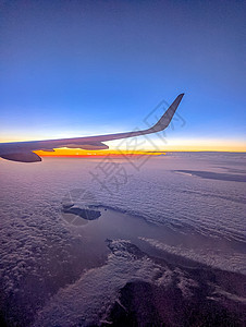 从一架飞机的窗口看到云和天空 从飞机的窗户看旅行航班气氛风景运输太阳地平线客机海洋空气图片