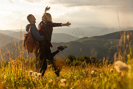 快乐旅行的年轻夫妇 在山上休息 日落在春季或夏季男性自由旅游女孩游客成人微笑冒险顶峰夫妻图片
