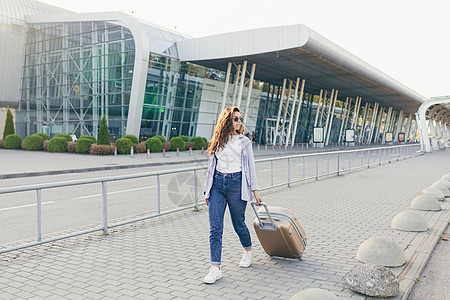 带着手提箱和电话的年轻美女 打电话给某人 寻找电话阅读旅行商务发型服装人士夹克飞机场摄影乘客图片