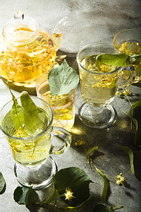 绿桌上新制的林顿茶和茶壶玻璃杯 有叶子和林顿树花图片