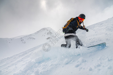 一位年轻时尚女孩在史诗般的山地背景下 在粉末上滑雪图片