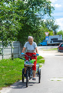 一位老妇人骑自行车 专心挑选公园城市自由街道享受微笑老年夫妻骑术闲暇图片