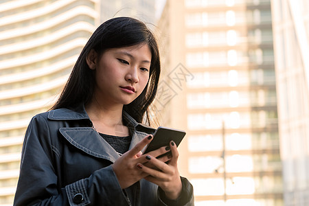 年轻女性咨询其手机的年青女性技术商务女孩细胞互联网电话金融优雅创新人士图片