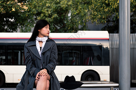 坐在等公车的亚洲女人坐着等待巴士背景