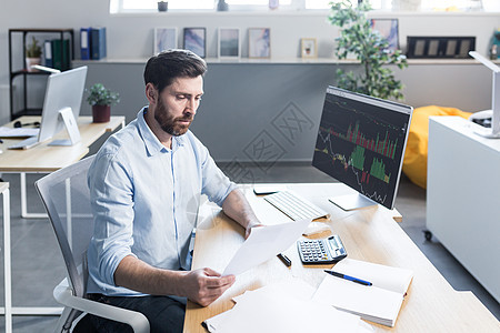 坐在办公室分析的监控屏幕前的有自信的商家股票经纪公司经理人报告库存公司利润职业机构交换金融男性贸易图片