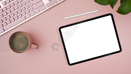 带有空显示的顶端视图数字平板板 符号笔 粉红色背景上的咖啡杯 女性工作场所图片