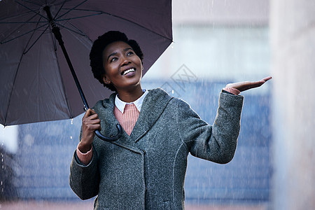 雨不会阻止我前进 一位年轻的女商务人士在城市背景下雨中散步时用雨伞遮盖图片