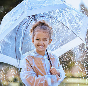 总是决心玩得开心 一个小女孩在雨中装腔作势地站在雨里拿着伞图片