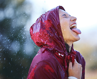 一位年轻女子伸出舌头感受外面的雨声 在雨中无忧无虑图片