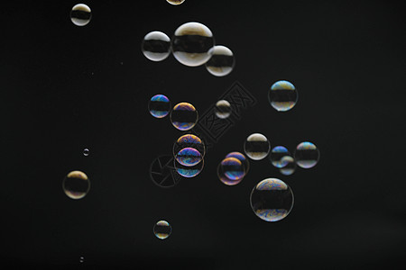 在黑色背景上飞行的肥皂泡 与五颜六色的反射的抽象肥皂泡 运动背景中的肥皂泡漂浮流动彩虹圆圈乐趣液体科学环形环境想像力图片