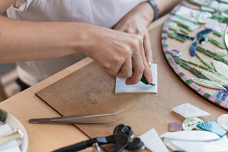 马赛克大师的工作场所 女性在制作马赛克过程中手持马赛克细节工具陶瓷刀具艺术品工作室女孩创造力爱好框架水平玻璃图片