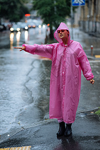 年轻女孩想拦下计程车 女人在雨天叫计程车手势雨衣成人女士快乐雨滴摄影运输出租车女性图片