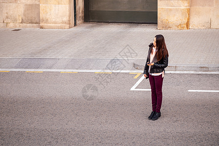 手拿着电话的女人在等计程车图片