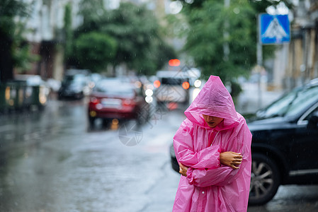 在雨中街上穿雨衣的可怜女人雨帽黑发外套衣服街道情感服饰女孩女性天气图片