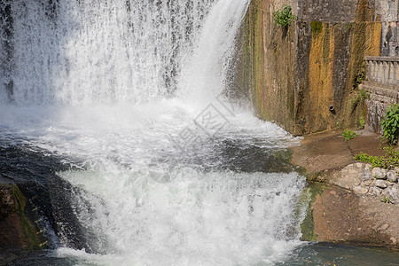 公园花园中的人工瀑布 城市公园的人造瀑布 喷泉中的水从花岗岩板上落下 呈宽条状 小型水电站大坝景观植物流动树木力量建筑吸引力环境背景