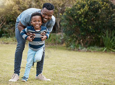 一个年轻父亲和儿子在花园外面玩耍时 和他儿子交情的一整拍子 就像爸爸一样图片