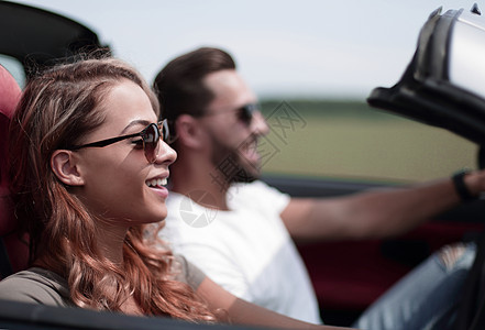 特写 一个年轻女人和她的男朋友在一辆敞篷车里太阳镜享受汽车女性车辆乐趣微笑成人成年人家庭图片