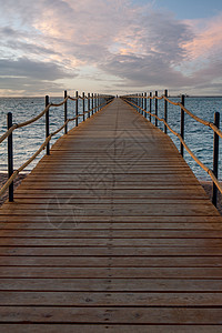 日出时 木林码头延伸到大海港口木头蓝色海岸旅游天空太阳地平线热带场景图片