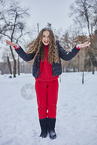一位快乐的年轻女子在冬季公园玩得开心 扔雪 手里冷 排放量不那么大白色男性男人女性假期微笑喜悦乐趣夫妻成人图片