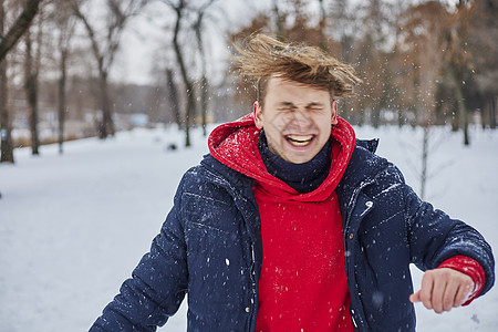 一个快乐的年轻人在冬季公园玩得开心 扔雪 手感寒冷 排放量不那么大森林微笑喜悦女士假期夫妻白色男性家庭乐趣图片