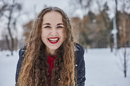 一位快乐的年轻女子在冬季公园玩得开心 扔雪 手里冷 排放量不那么大闲暇女性成人女士幸福家庭男人夫妻乐趣喜悦图片