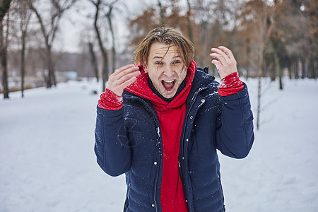 一个快乐的年轻人在冬季公园玩得开心 扔雪 手感寒冷 排放量不那么大假期男性夫妻女士喜悦乐趣幸福微笑白色女性图片