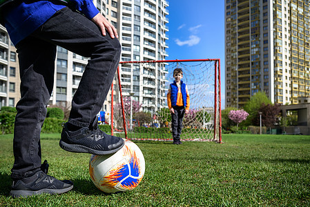 小学龄前男孩朋友在外郊游草场踢足球 快乐真实 坦诚的童年生活方式 夏季季节性户外活动 为孩子们举办球赛以及闲暇幼儿园公园游戏运动图片