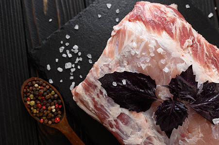 一个大块猪肉卷 和Basil 在生锈的黑暗背景胡椒肋骨木头厨房牛肉木板迷迭香草本植物香料烹饪图片