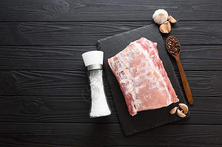 一大块猪肉卷 在生锈的黑暗背景鱼片香料牛扒烧烤肋骨厨房迷迭香木头屠夫桌子图片