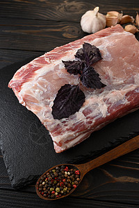 一个大块猪肉卷 和Basil 在生锈的黑暗背景炙烤牛扒鱼片木头食物烹饪屠夫胡椒桌子牛肉图片