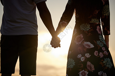 牵着我的手 把我的整个生命也带走 一个无法辨认的夫妇在看日落时手牵手图片
