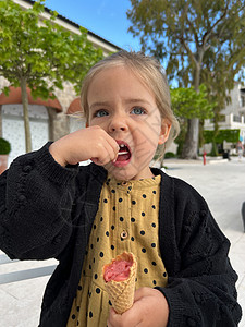 小女孩吃冰淇淋甜甜筒和一块烟锅图片